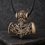 Bronze Viking Mjolnir pendant with wolf and raven motifs on dark stone