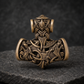 Front view of bronze Thor’s Hammer pendant with Norse knotwork and animal detailing