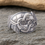 Silver Raven ring with intricate designs on a stone surface