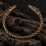 Thunderbird bronze armring with twisted band displayed on dark rustic wood background