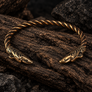 Open Thunderbird bronze armring in detailed product photo on dark textured wood surface