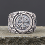 Silvered Bronze Viking Ring With Vegvisir and Jormungandr on a rocky surface