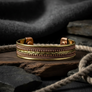 Close-up of copper and brass cuff bracelet showing braided wire craftsmanship and magnetic terminals