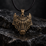 Bronze Fenrir wolf pendant with Norse knotwork on dark wet stone