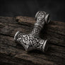 Reverse view of 925 sterling silver Mjolnir pendant showing interlaced Norse knotwork on dark wood