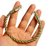 Handmade Viking Urnes dragon head brass armring shown in hand with braided twisted band