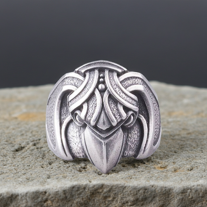 Silvered bronze ring ring raven design on a stone surface