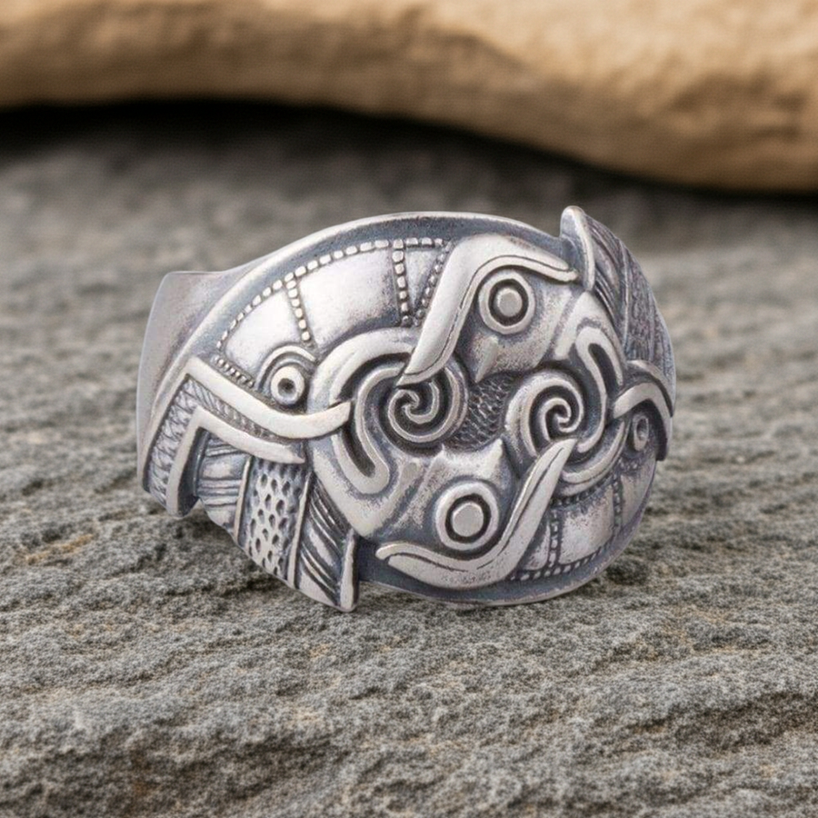 Silver Raven ring with intricate designs on a stone surface