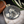 Silver Spartan helmet pendant on a marble surface with olive branch