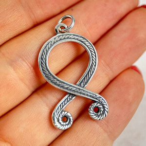Silver Troll Cross pendant shaped like a question mark held in a hand