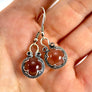 Silver Gotland earrings with crystal rock gemstones held in a hand