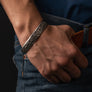 Jelling style sterling silver Viking armring worn on the wrist with detailed Norse-inspired engraving