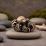 Angled view of octopus bronze figurine displayed on natural stone